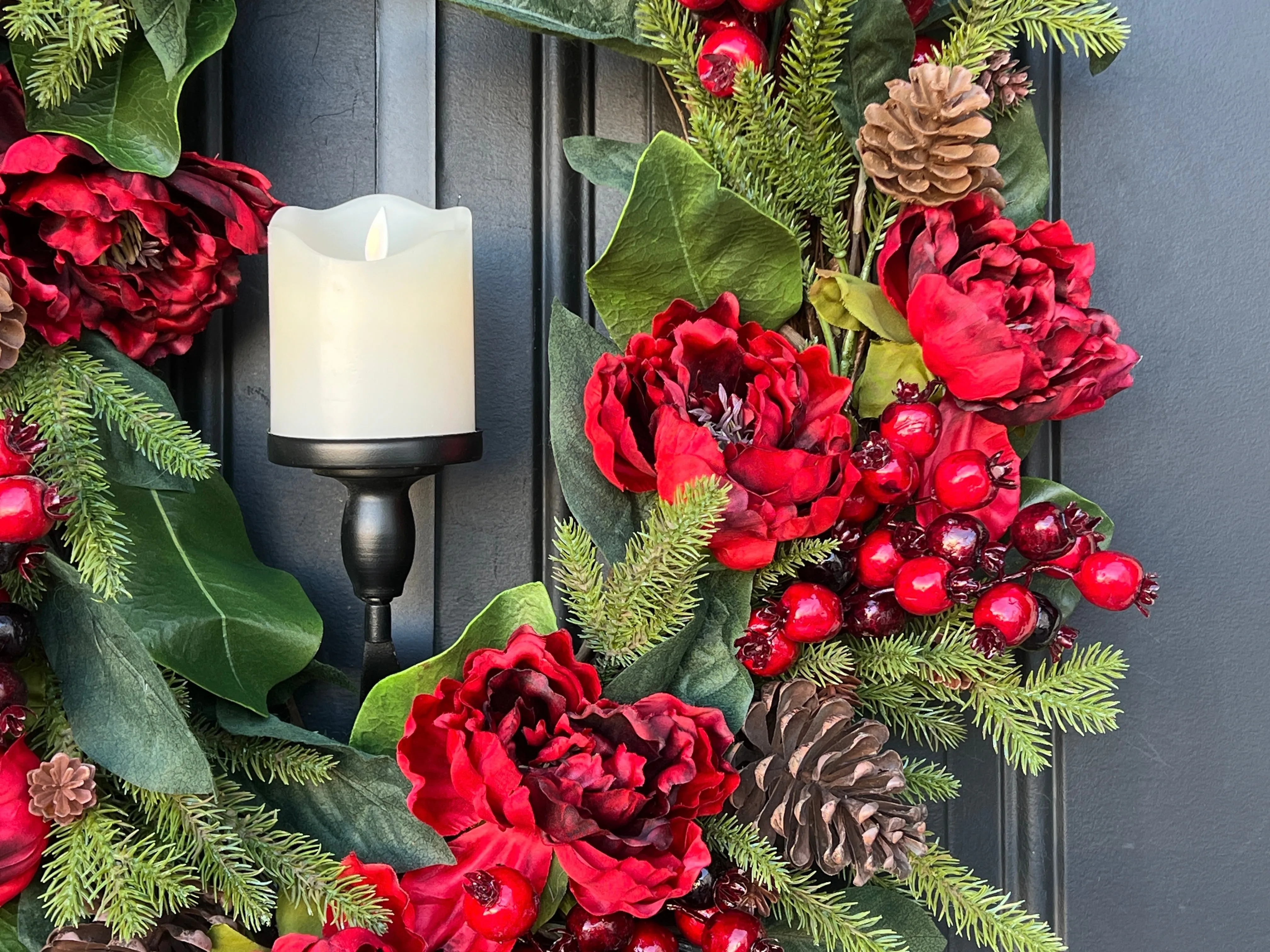 Oval Red and Green Christmas Wreath with Pinecones and Flickering Candle