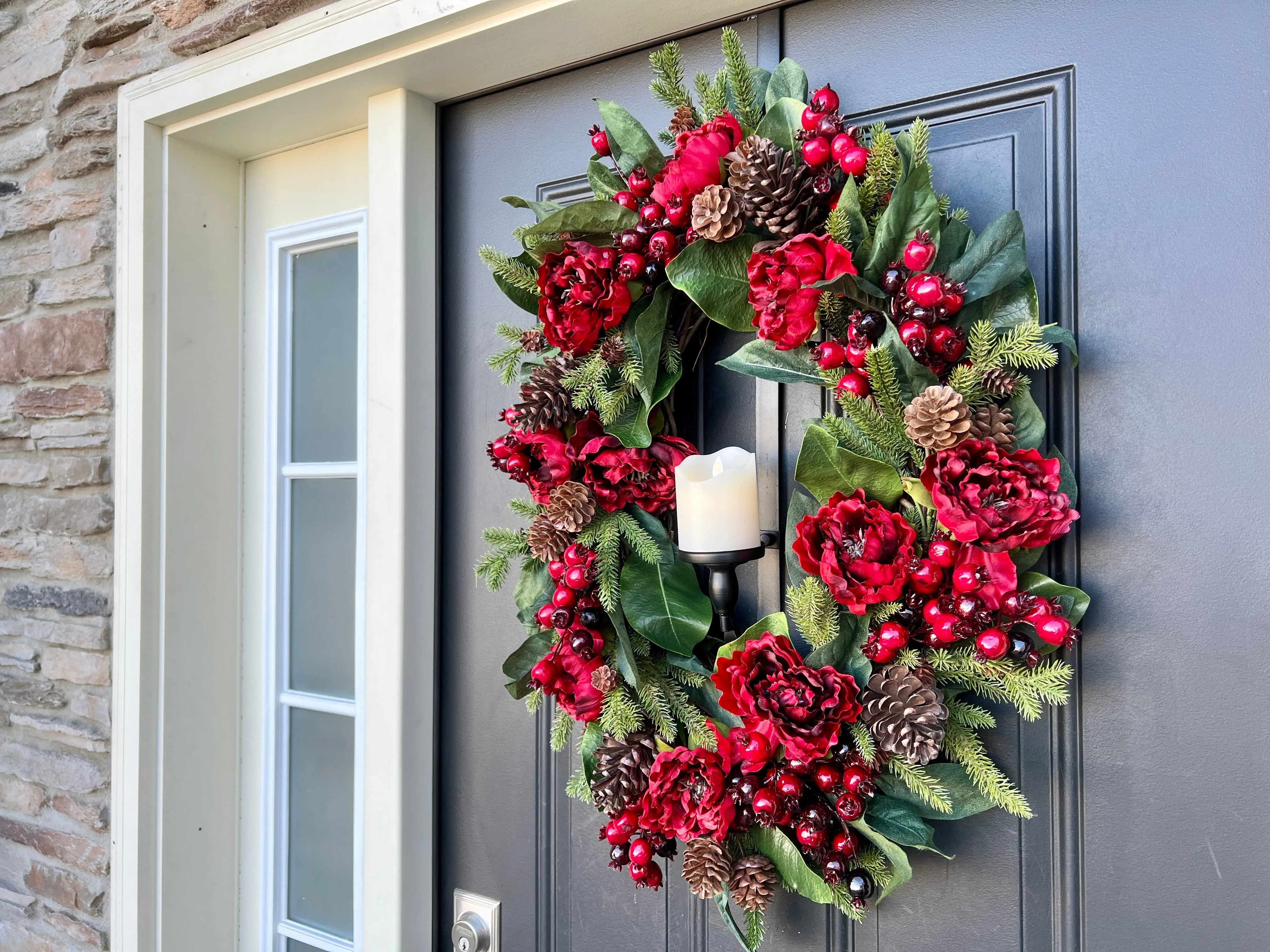 Oval Red and Green Christmas Wreath with Pinecones and Flickering Candle