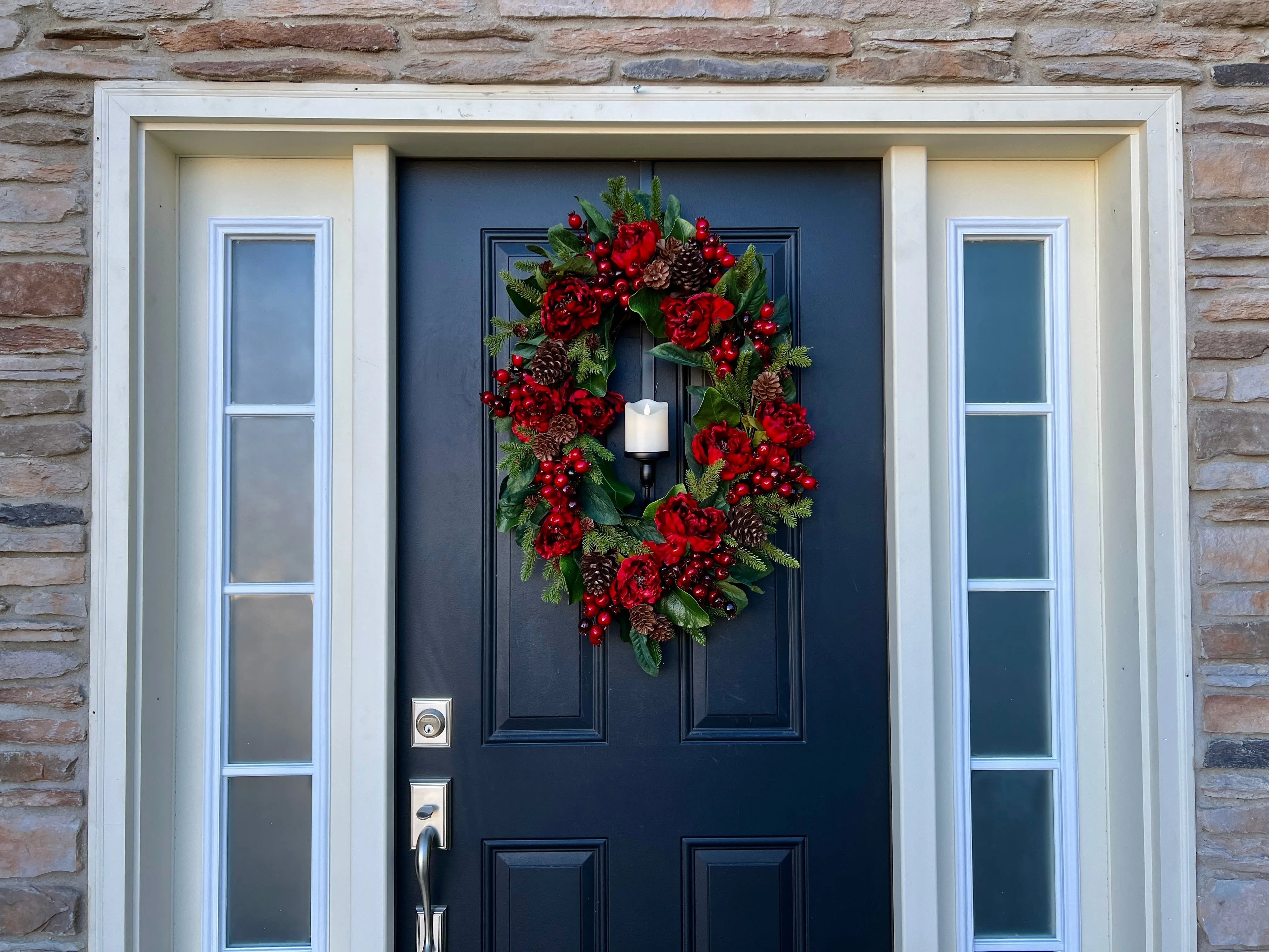 Oval Red and Green Christmas Wreath with Pinecones and Flickering Candle