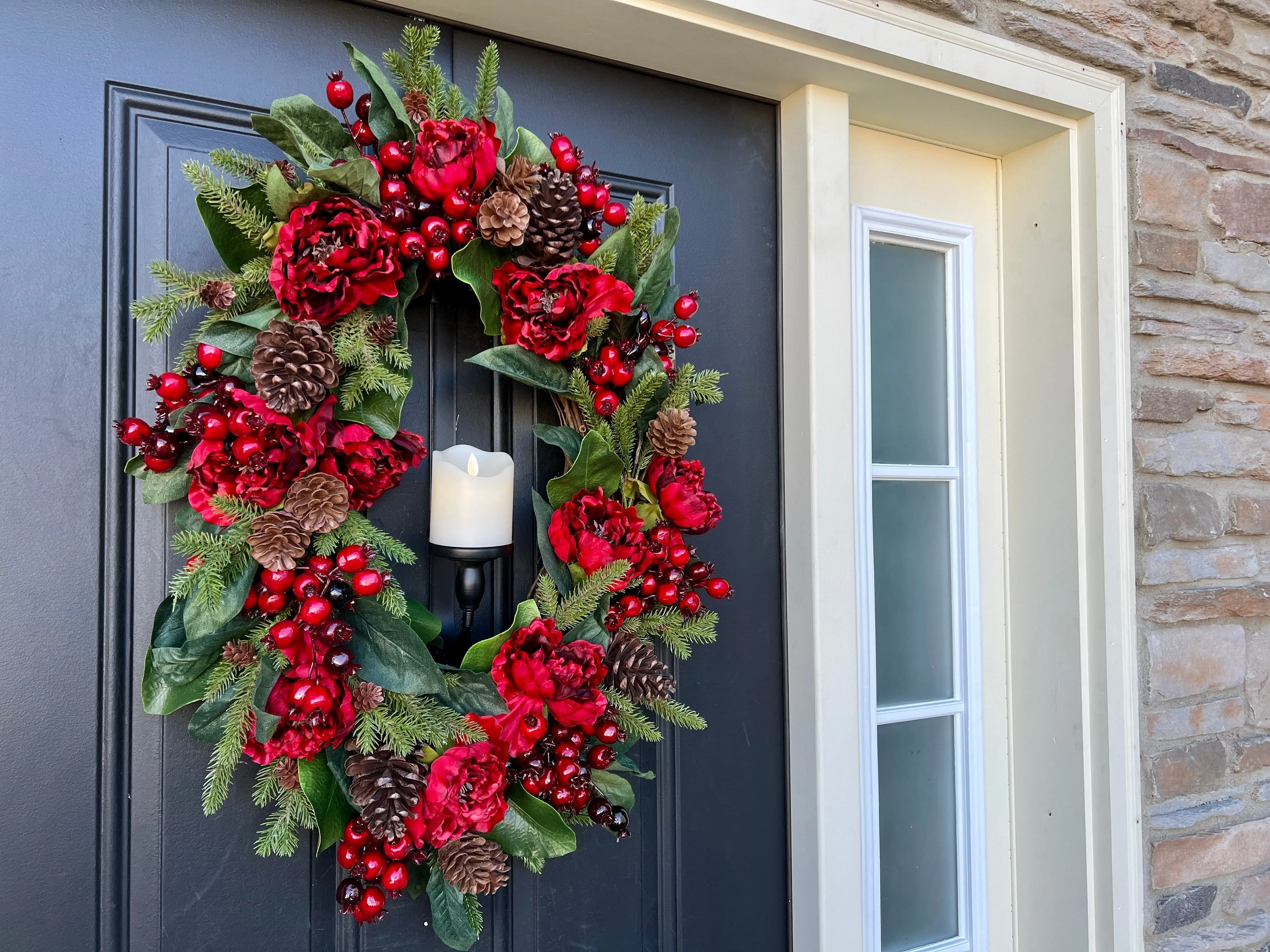 Oval Red and Green Christmas Wreath with Pinecones and Flickering Candle